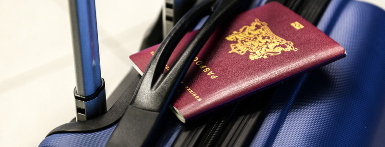 On a blue suitcase is a passport.